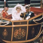 a bride and groom riding in a horse drawn carriage