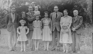 grayscale photo of family standing near trees
