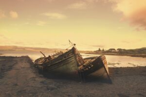 brown wreck boat near seashore during daytime
