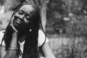 grayscale photography of woman resting head on her right palm